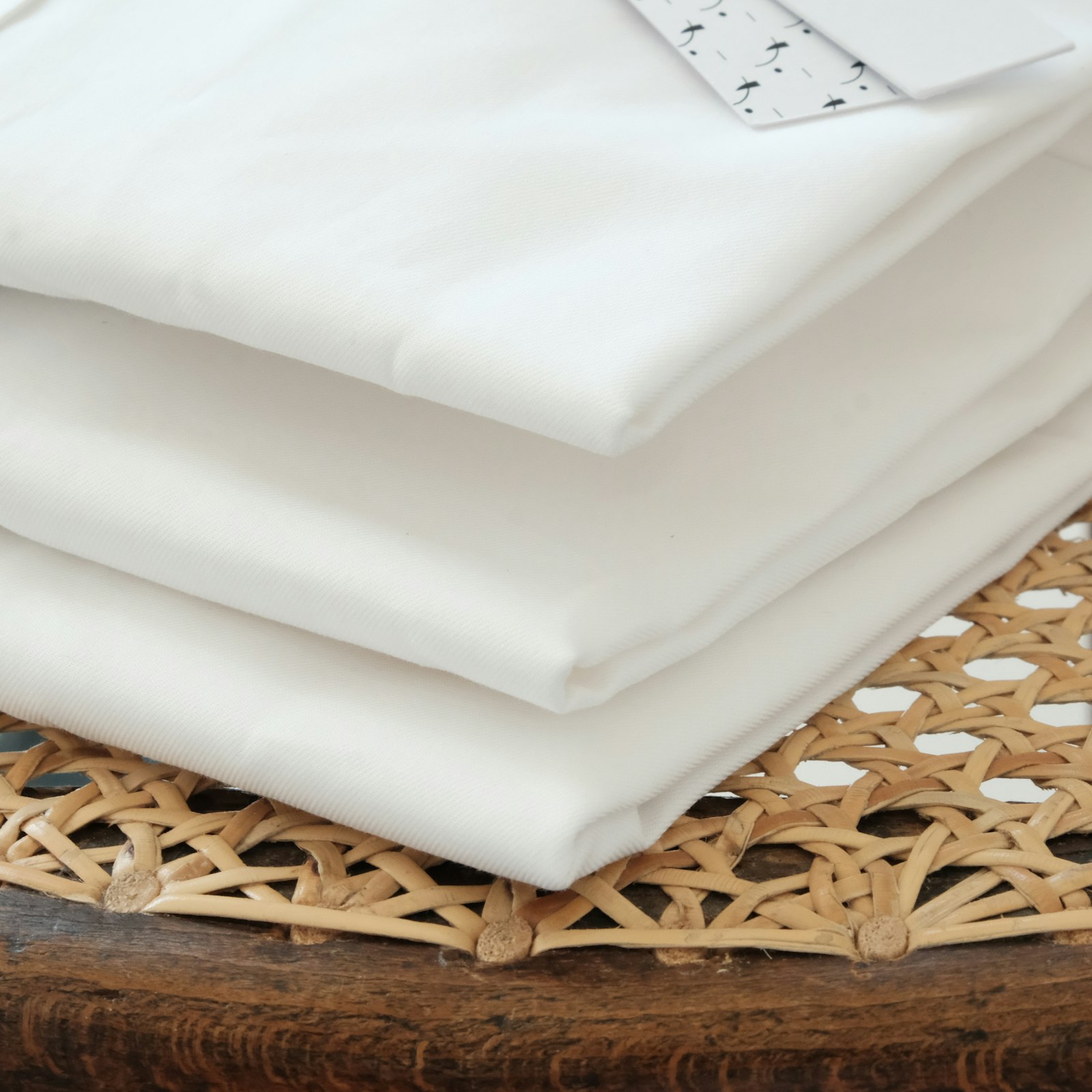 Vải lanh gấp xếp chồng trên rổ mây